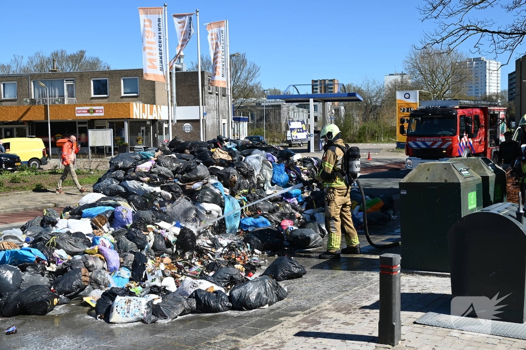 Brandweer blust brandende inhoud vuilniswagen