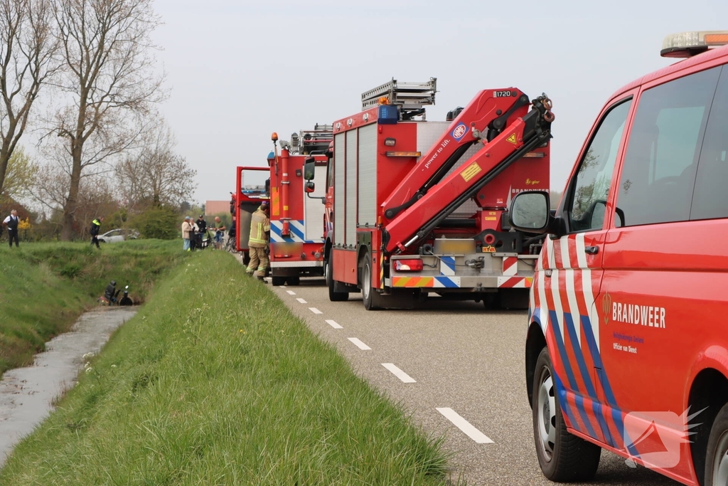 Persoon te water met scootmobiel