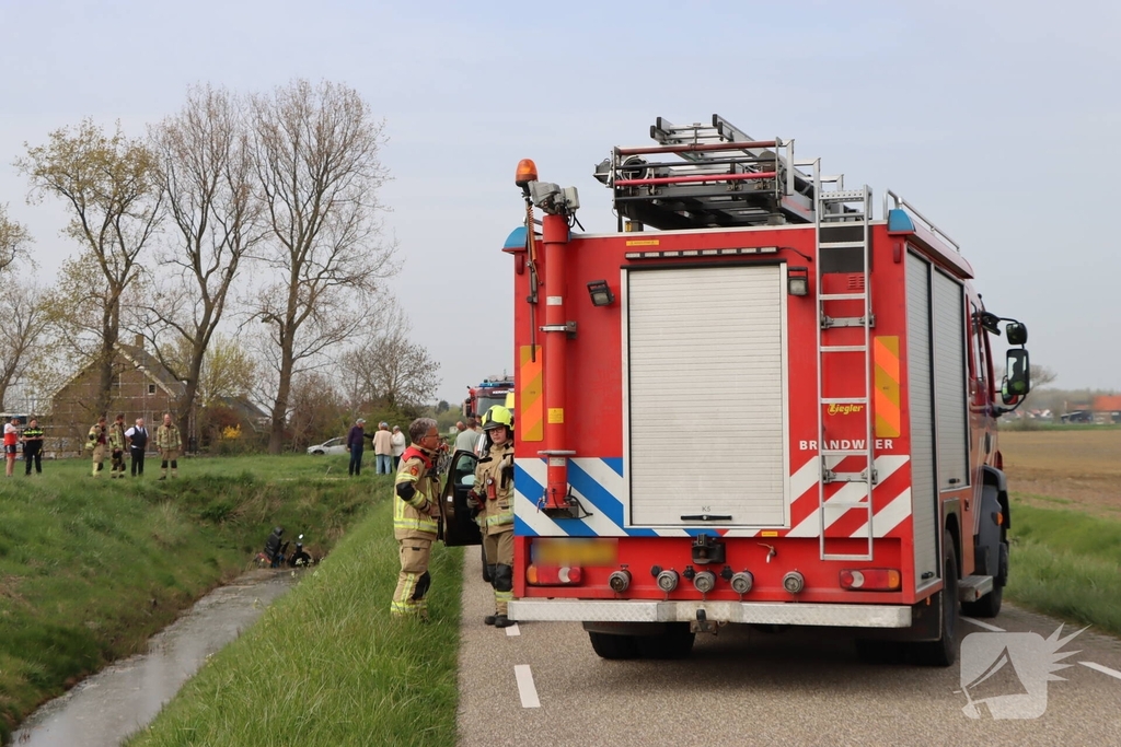 Persoon te water met scootmobiel