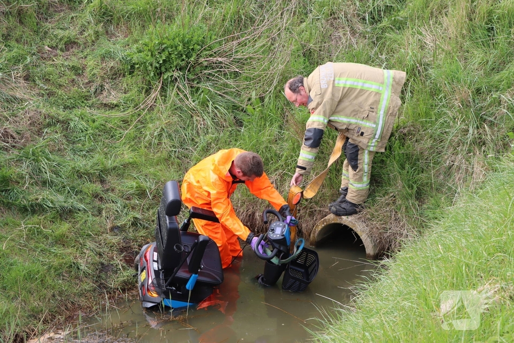 Persoon te water met scootmobiel