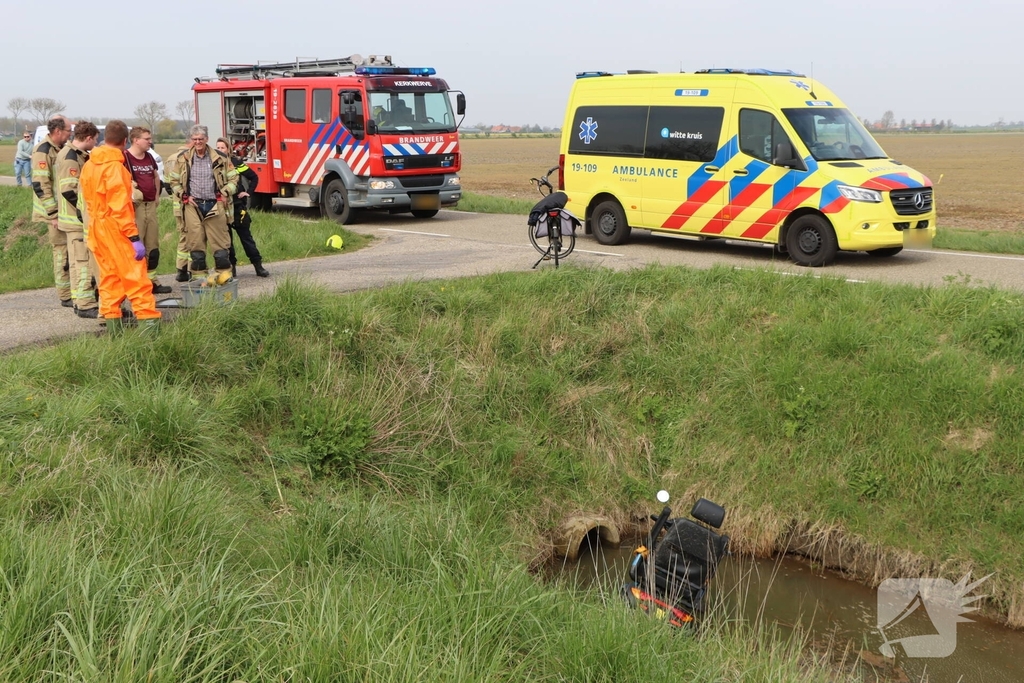 Persoon te water met scootmobiel