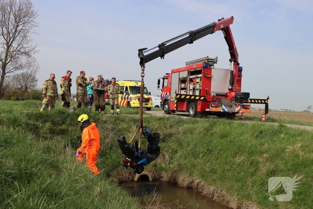Persoon te water met scootmobiel