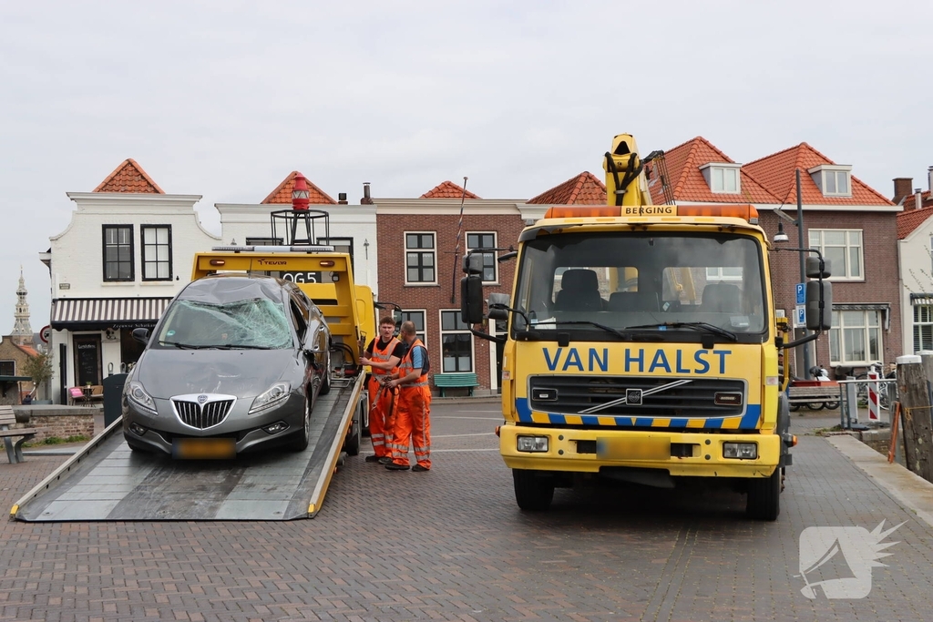 Auto op de kop op steiger na vergeten handrem