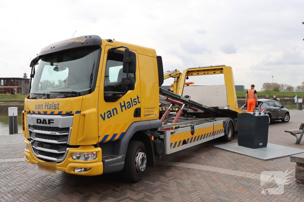 Auto op de kop op steiger na vergeten handrem