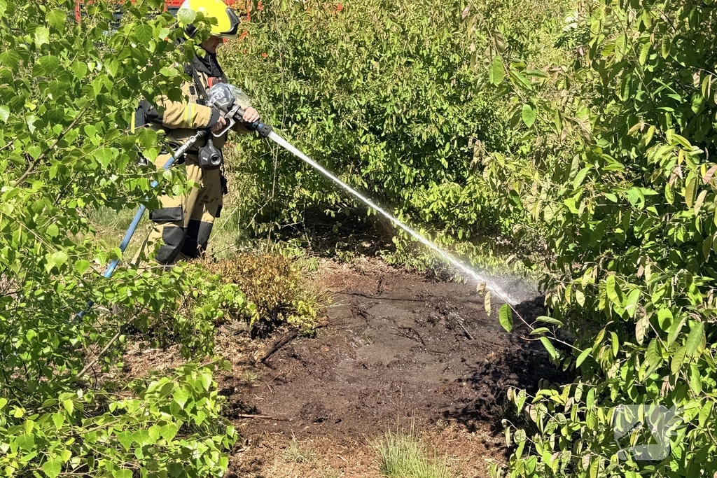 Brandweer blust buitenbrand in bos
