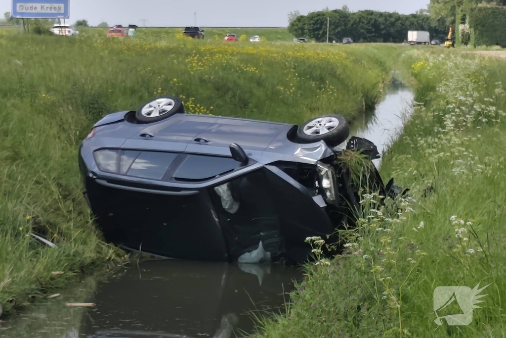 Auto belandt op zijkant in sloot naast snelweg