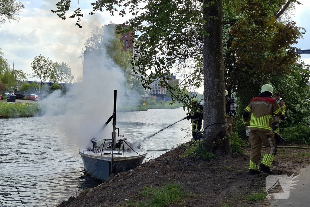 Brandweer blust felle brand op kleine zeilboot