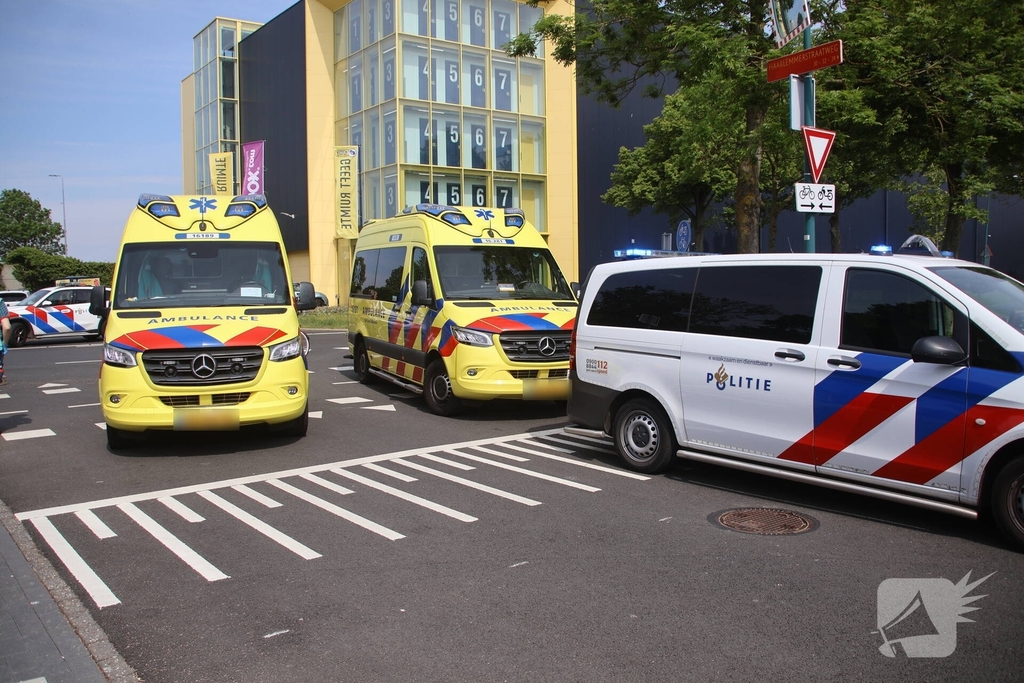 Omstanders halen inzittenden uit te water geraakt voertuig