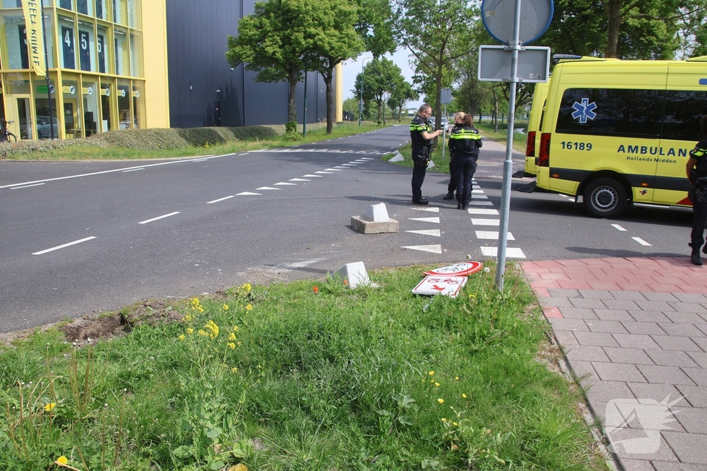 Omstanders halen inzittenden uit te water geraakt voertuig