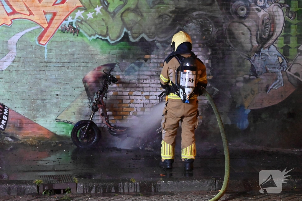 Scooter in brand naast opslag bij Kwik Fit