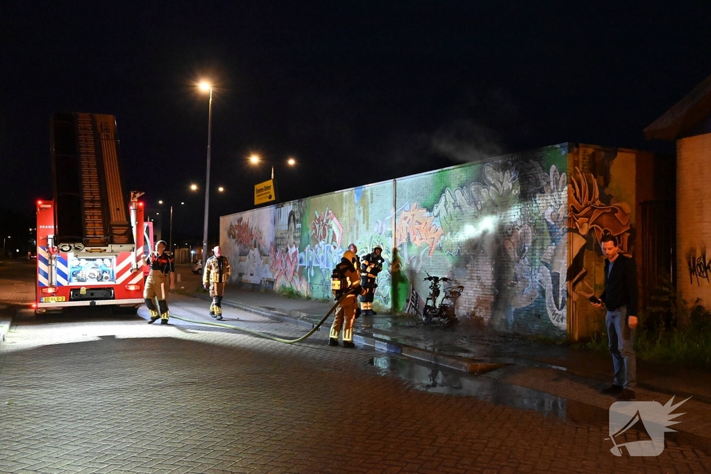 Scooter in brand naast opslag bij Kwik Fit