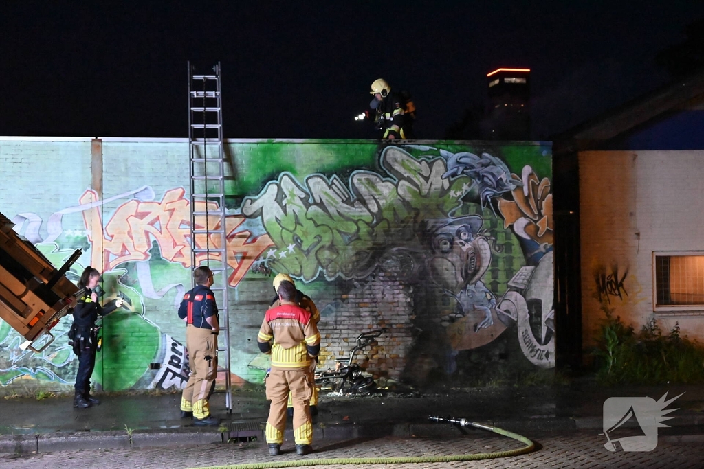 Scooter in brand naast opslag bij Kwik Fit