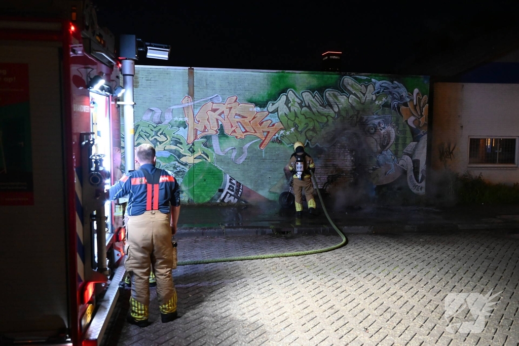 Scooter in brand naast opslag bij Kwik Fit