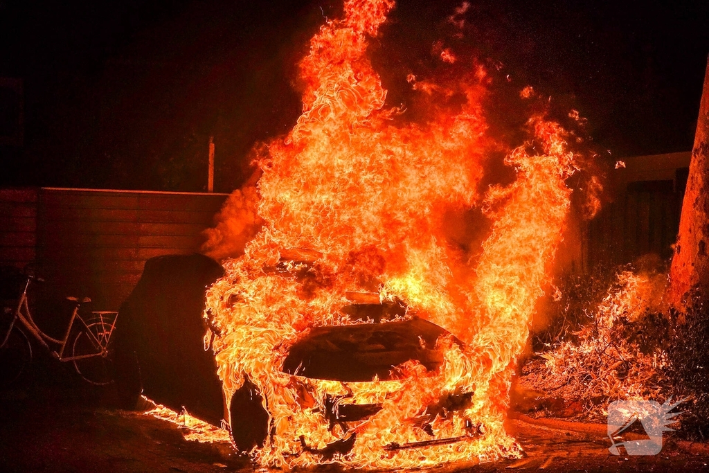 Auto brandt volledig uit met schade aan omringende schuttingen