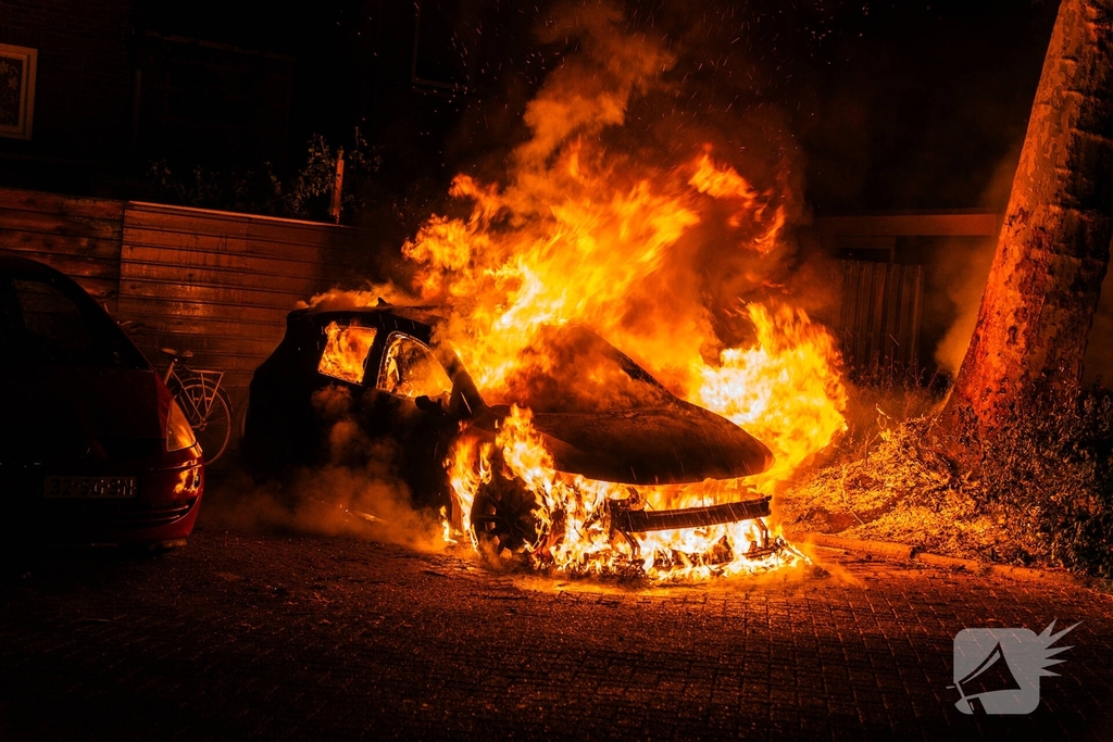 Auto brandt volledig uit met schade aan omringende schuttingen