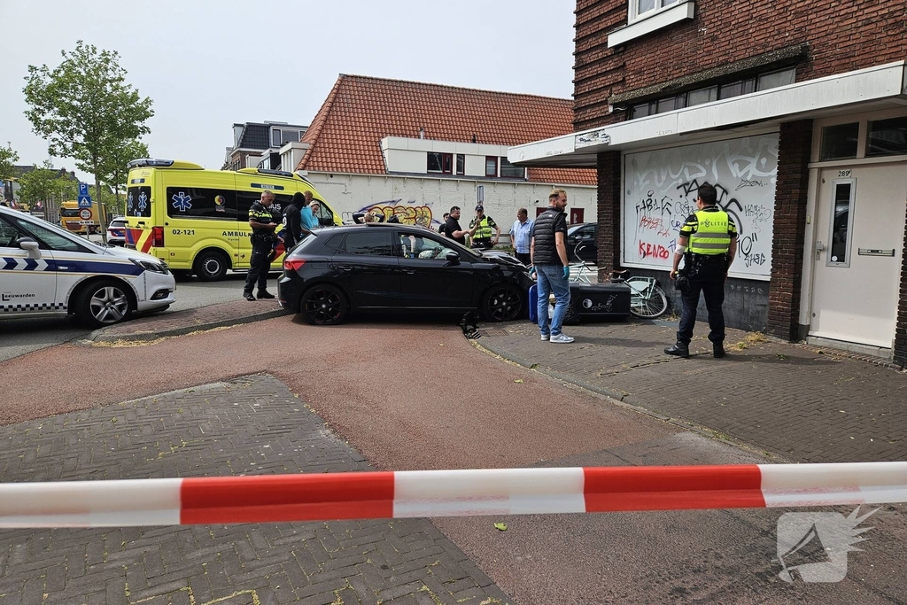 Automobilist crasht op rotonde en botst tegen woning