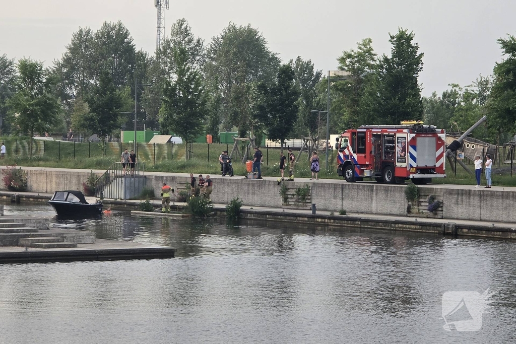 Brandweer haalt boot naar kade na brand