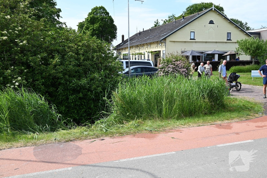 Persoon op driewieler raakt te water