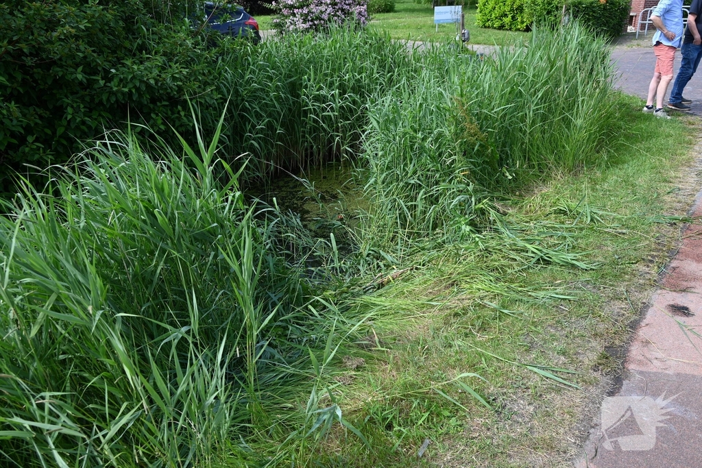 Persoon op driewieler raakt te water