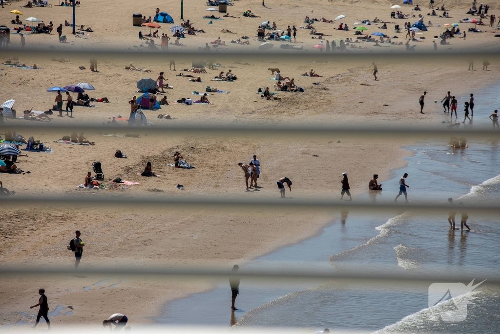 Mensen zoeken verkoeling aan zee
