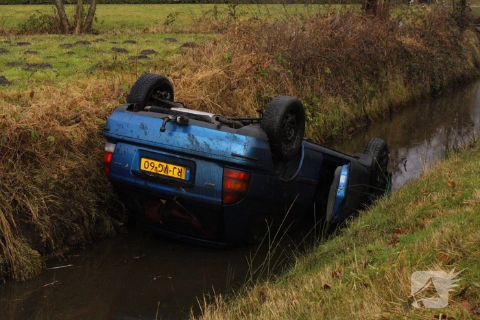 Auto vliegt uit bocht en komt ondersteboven in sloot
