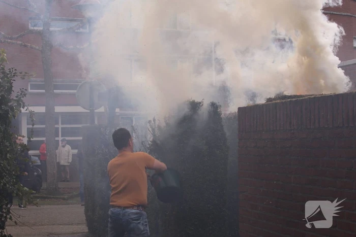 Brandweer blust brandende coniferenhaag