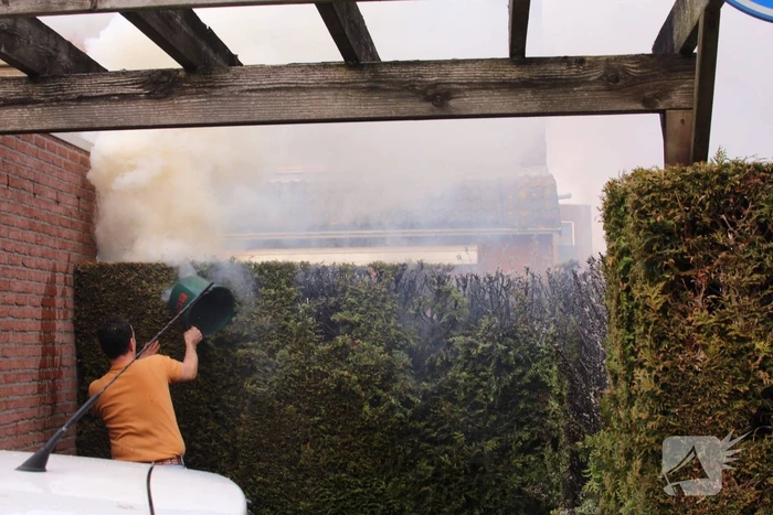 Brandweer blust brandende coniferenhaag