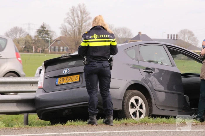 Auto duikt vangrail in