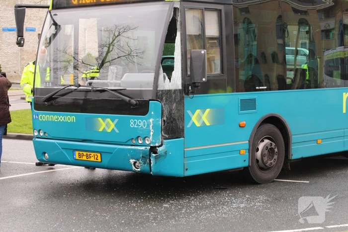 Stadsbus rijdt auto tegen lantaarnpaal