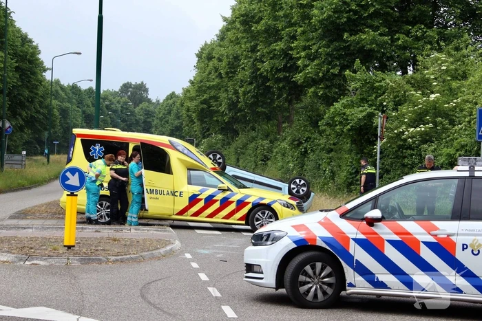 Auto over de kop na botsing