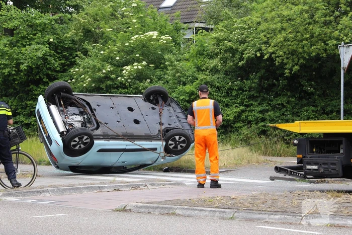 Auto over de kop na botsing