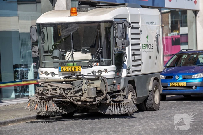 Veegwagen botst op personenauto