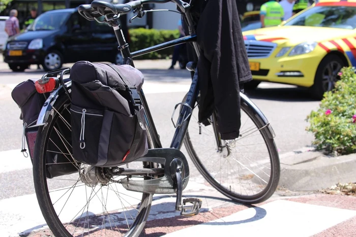 Fietser geschept door auto op rotonde