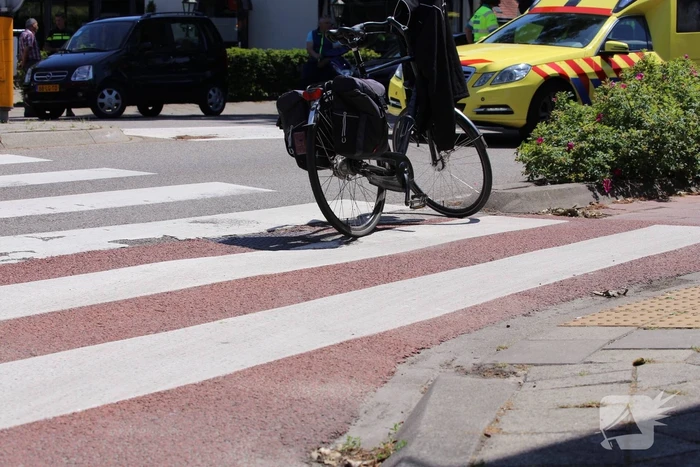 Fietser geschept door auto op rotonde