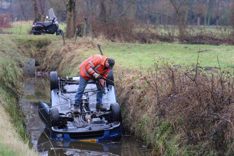 Auto vliegt uit bocht en komt ondersteboven in sloot