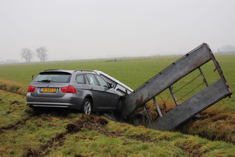 Bestelbus met aanhanger belandt in de sloot