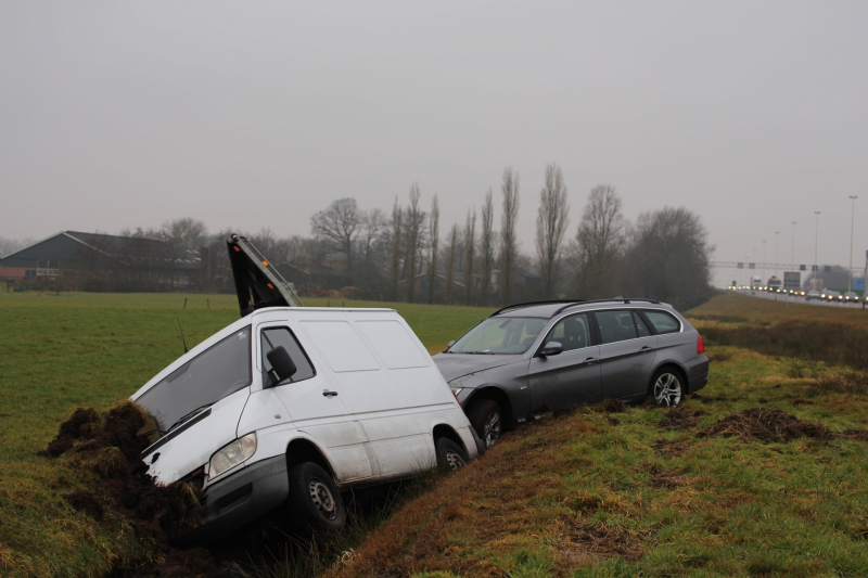 Bestelbus met aanhanger belandt in de sloot
