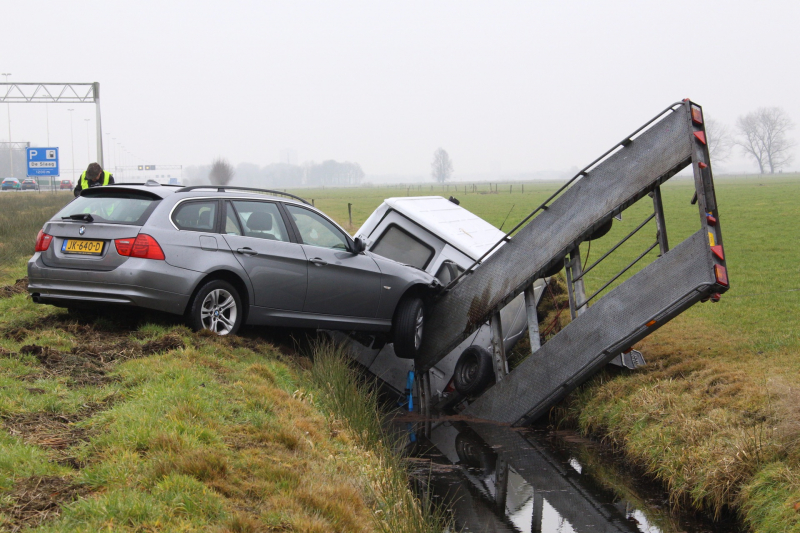 Bestelbus met aanhanger belandt in de sloot