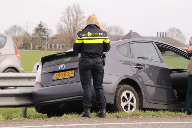 Auto duikt vangrail in