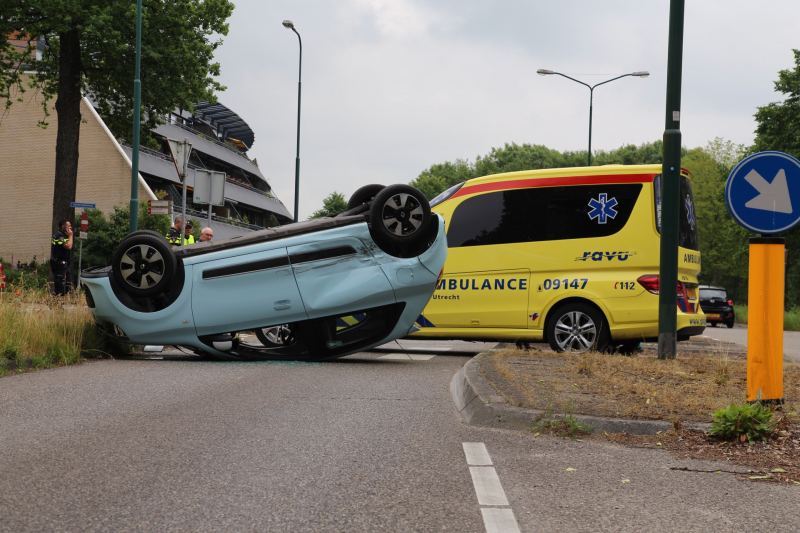 Auto over de kop na botsing