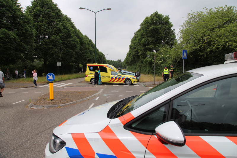 Auto over de kop na botsing