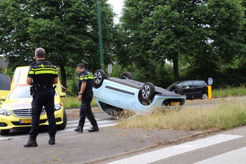 Auto over de kop na botsing