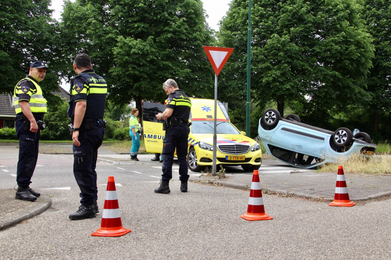 Auto over de kop na botsing