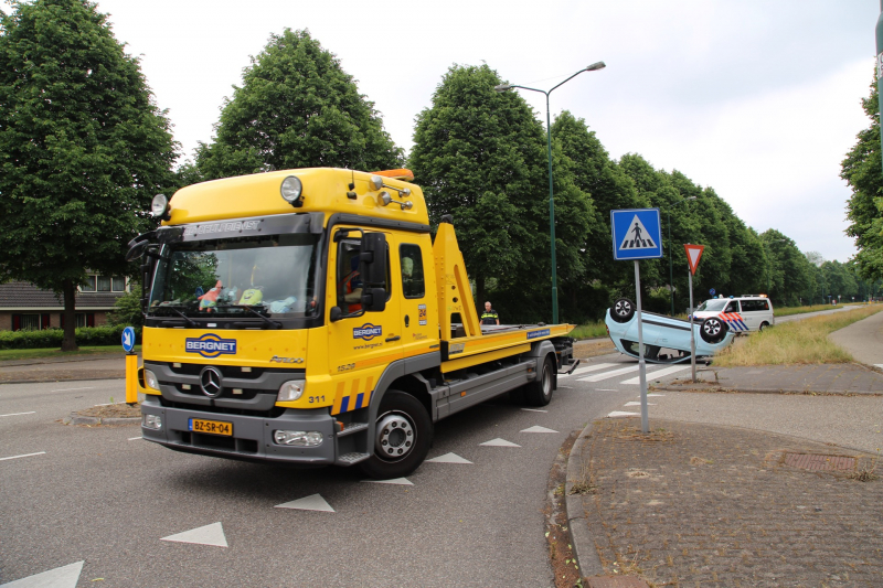 Auto over de kop na botsing