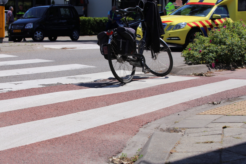 Fietser geschept door auto op rotonde