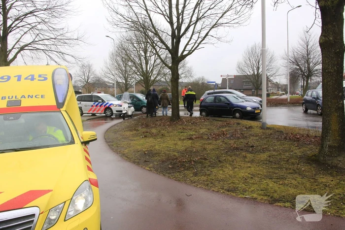 Auto en scooter botsen op rotonde
