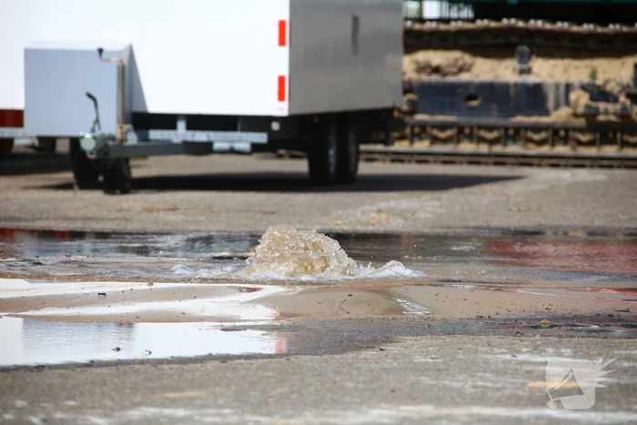 Kraan rijdt over waterleiding en zorgt voor waterballet