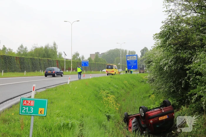 Auto te water geraakt op afrit snelweg