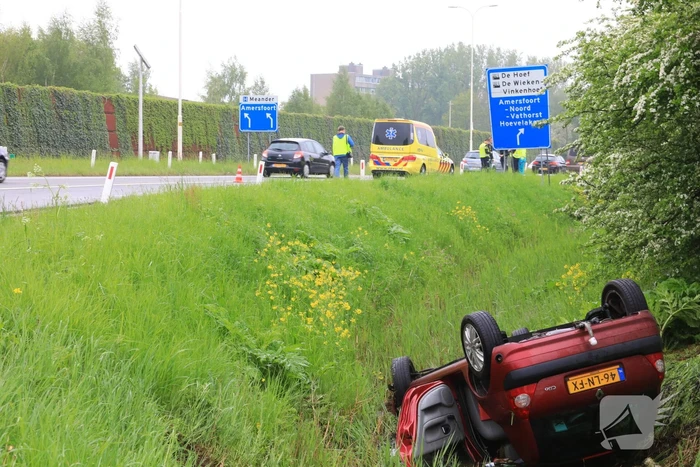 Auto te water geraakt op afrit snelweg