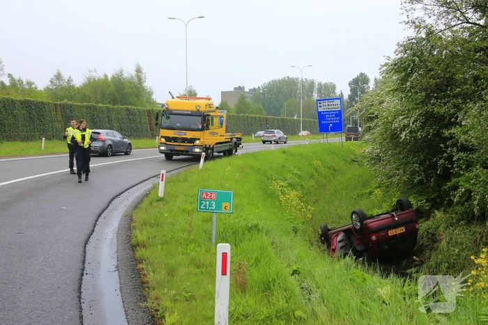 Auto te water geraakt op afrit snelweg